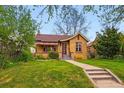 Attractive home with lush green lawn and mature trees, nestled in a quiet neighborhood at 1312 Ash St, Denver, CO 80220