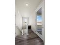 Hallway view with stylish wood floors, a stairway to basement and large glass door to outdoor space at 350 High Point Dr # C201, Longmont, CO 80504
