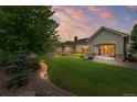 Expansive backyard featuring lush greenery, a manicured lawn, and inviting patio area with a cozy firepit at 14310 Inca St, Westminster, CO 80023