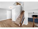 Bright entryway with hardwood floors, staircase with carpet and wood railing, and access to living spaces at 5495 Bobcat St, Frederick, CO 80504