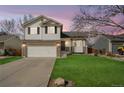 Charming two-story home featuring a two-car garage, manicured lawn, and beautiful stone accents at 5495 Bobcat St, Frederick, CO 80504