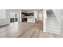 Open-concept living space with wood floors, seamlessly connecting the living room, kitchen, and staircase at 21142 E 63Rd Dr, Aurora, CO 80019