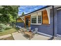 Inviting front porch with chairs, wood accents, updated brick, and appealing curb appeal for relaxed outdoor living at 12020 W Alabama Pl, Lakewood, CO 80228