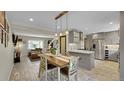 Open concept kitchen features stainless appliances, a kitchen island and dining area, and abundant natural light at 12020 W Alabama Pl, Lakewood, CO 80228