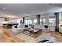 Open concept living room features hardwood floors and sliding glass doors to the outside at 6521 Barnstead Dr, Castle Pines, CO 80108