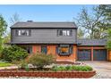 Charming two-story home with a brick and siding exterior, lush landscaping and a two car garage at 2448 S Leyden St, Denver, CO 80222