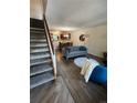 Open-concept living space with modern flooring, comfortable seating, and staircase access at 1240 S Flower Cir # A, Lakewood, CO 80232