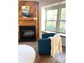Cozy living room featuring a fireplace, accent chair, and large windows for natural light at 1240 S Flower Cir # A, Lakewood, CO 80232