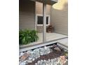 Charming deck area with manicured rock details, landscaping, and a planter with vibrant red flowers at 6980 Fargo Trl, Littleton, CO 80125