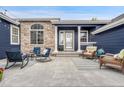 Welcoming front porch features a cozy seating area with comfortable chairs, an outdoor rug, and stylish decorations at 10233 Greatwood Ct, Highlands Ranch, CO 80126