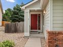 Charming single-Gathering home features a red front door, rock garden and brick accents at 386 Monte Vista St, Brighton, CO 80601