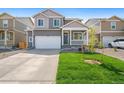 Two-story house with gray siding, white garage door, and landscaped lawn at 15963 Syracuse St, Thornton, CO 80602