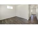 Empty spare bedroom with dark gray vinyl plank flooring and a window at 15963 Syracuse St, Thornton, CO 80602