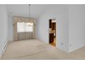 Cozy living room featuring neutral walls, a chandelier and a glimpse into the kitchen at 8204 S Cody St, Littleton, CO 80128