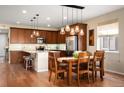 Open concept kitchen with stainless appliances and wooden dining table at 18067 E Anthem Dr, Parker, CO 80134