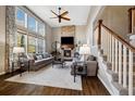 Elegant living room featuring a stone fireplace, hardwood floors, and large windows at 15218 W La Salle Ave, Lakewood, CO 80228