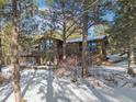 Beautiful mountain home surrounded by mature trees and a snowy landscape at 9142 Warriors Mark Dr, Franktown, CO 80116