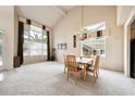 Bright dining room boasts a vaulted ceiling, large windows, and a modern chandelier at 13560 Detroit St, Thornton, CO 80241