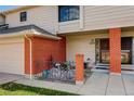 Brick townhouse entryway, with a white bicycle and garden at 4618 S Newton St, Denver, CO 80236