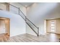 Bright foyer with high ceilings, hardwood floors and staircase with metal railing offer a modern and stylish look at 8596 Hotchkiss St, Littleton, CO 80125