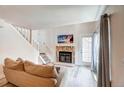 Comfortable living room with stone fireplace, staircase and sliding door at 919 S Dawson Way # 14, Aurora, CO 80012