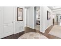 Bright hallway featuring hardwood floors, white trim, and neutral wall color at 18922 W 84Th Ave, Arvada, CO 80007
