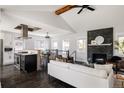 Inviting living room with stacked stone fireplace, modern lighting, and open flow to the kitchen and dining areas at 2995 N Cherry St, Denver, CO 80207