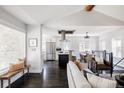 Open-concept living room showcasing dark hardwood floors, modern furnishings, and seamless flow to the kitchen at 2995 N Cherry St, Denver, CO 80207