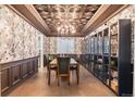 Elegant dining room with ornate ceiling, sophisticated wallpaper, and ample built-in shelving for storage and display at 10546 Sundial Rim Rd, Highlands Ranch, CO 80126