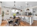 Bright eat-in kitchen boasts an island with bar seating, stainless appliances, and modern pendant lighting at 10546 Sundial Rim Rd, Highlands Ranch, CO 80126