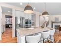 Spacious kitchen island with modern lighting, stainless appliances, and hardwood floors at 10546 Sundial Rim Rd, Highlands Ranch, CO 80126