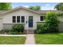 Close up of the front door of a charming home with a well-kept lawn and landscaped shrubs at 6402 Iris Ct, Arvada, CO 80004