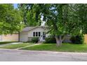 Quaint single-story home with lush green lawn and mature shade trees. A peaceful suburban setting at 6402 Iris Ct, Arvada, CO 80004