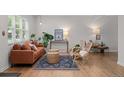 Bright living room with hardwood floors, a cozy sofa, and stylish rattan furniture creates an inviting space at 6402 Iris Ct, Arvada, CO 80004
