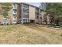 Three-story condo building with glass-enclosed patios and a large grass lawn at 3022 S Wheeling Way # 407, Aurora, CO 80014