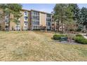 Three-story condo building with glass-enclosed patios and mature trees at 3022 S Wheeling Way # 407, Aurora, CO 80014