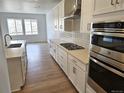 Well-lit kitchen features stainless steel appliances, gas cooktop, and white cabinets at 17146 W 92Nd Loop, Arvada, CO 80007