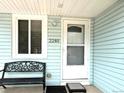 Close-up of a welcoming front porch with a bench, house number, and white-trimmed door at 2285 S Knox Ct, Denver, CO 80219
