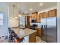 Well-lit kitchen with granite countertops, stainless steel appliances, and bar seating at 23688 E Ida Dr # E, Aurora, CO 80016