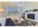 Cozy living room with a fireplace, large windows, and a modern rug over hardwood floors at 23688 E Ida Dr # E, Aurora, CO 80016