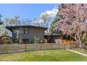 A modern home with a black roof, fenced-in front yard, and fresh landscaping at 1485 S Jasmine Way, Denver, CO 80224