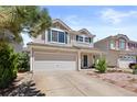 Two-story home with attached two-car garage, neutral siding and green shutters in a residential neighborhood at 19817 E 47Th Pl, Denver, CO 80249