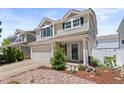 Two-story home with attached two-car garage, neutral siding and green shutters in a residential neighborhood at 19817 E 47Th Pl, Denver, CO 80249