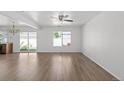 Bright living room with hardwood floors, ceiling fan, and sliding glass doors to the backyard at 19817 E 47Th Pl, Denver, CO 80249
