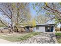 Inviting front exterior of a single-story home featuring a well-kept lawn and a convenient carport at 5567 E Asbury Ave, Denver, CO 80222