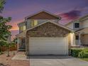 Charming two-story home with a stone-accented garage and well-maintained lawn under a vibrant evening sky at 8065 Clay St, Westminster, CO 80031