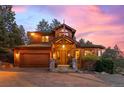 Stunning craftsman home with an attached garage, stone accents, a charming front porch and beautiful outdoor lighting at 394 S Ponderosa Way, Evergreen, CO 80439