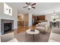Open-concept living room featuring a fireplace, hardwood floors, and seamless flow to the kitchen at 13986 Lexington Dr, Parker, CO 80134