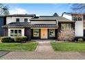 This modern home boasts dark brick, stylish windows, an inviting entrance, and a perfectly manicured lawn at 1 Sedgwick Dr, Cherry Hills Village, CO 80113