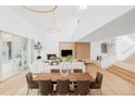 Bright living room with soaring ceilings, natural light, a cozy fireplace, and an adjacent dining area at 1 Sedgwick Dr, Cherry Hills Village, CO 80113